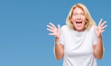 Orta yaş sarışın kadın deli kutluyor arka plan izole ve başarı için kaldırdı kollarını açarak hayrete ve heyecanlı çığlık gözleri açık. Kazanan kavramı