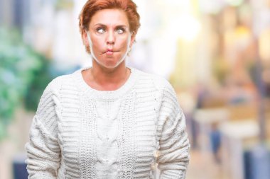 Üzerinde kış kazak giyen Atrractive üst düzey beyaz Kızıl saçlı kadın arka plan yapma balık yüz dudaklı, çılgın ve komik bir jest izole. Komik ifade.