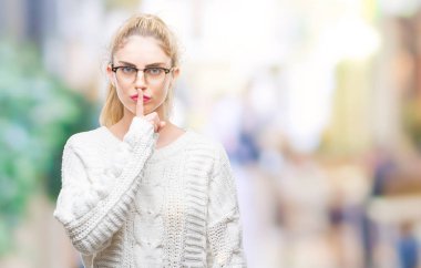 Dudaklarında parmak ile sessiz olmanı izole arka plan üzerinde gözlük takan genç güzel sarışın bir kadın. Sessizlik ve gizli kavramı.