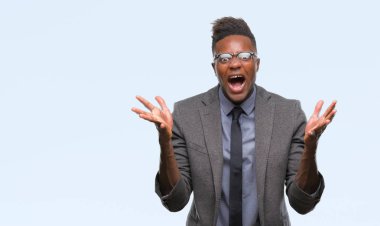 Genç Afro-Amerikalı iş adamı üzerinde arka plan çılgın kutlama izole ve başarı için kaldırdı kollarını açarak hayrete ve heyecanlı çığlık gözleri açık. Kazanan kavramı