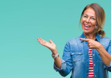 Orta yaş üzerinden hayran ve el ile sunulması ve parmak ile işaret ederken kameraya gülümseyen izole arka plan İspanyol kadın kıdemli.