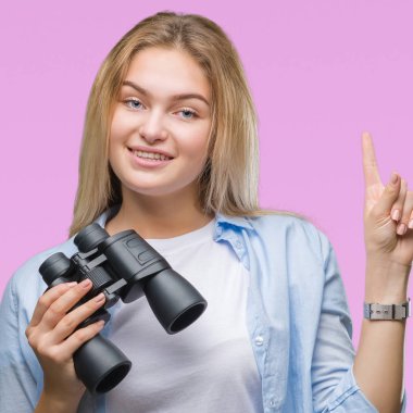 Genç kafkas kadın holding dürbün üzerinden arka plan ile bir fikir ya da gülen yüz, bir numara ile parmak işaret soru sürpriz izole
