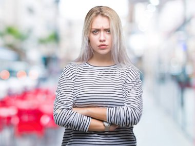 Genç Sarışın kadın izole arka plan şüpheci ve çapraz kolları olan yüzündeki gergin, onaylamayan ifade yüzünden. Negatif kişi.