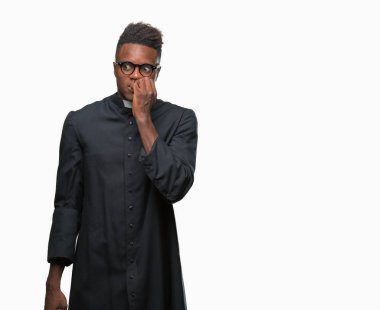 Genç Afro-Amerikan rahip adam stresli ve gergin elle çivi ısırma ağzına bakarak izole arka plan üzerinde. Anksiyete sorunu.