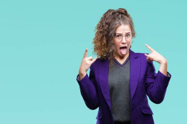 Genç esmer öğrenci kız deli ifade rock simge elle yapıyor ile bağırarak izole arka plan üzerinde okul üniforması ve gözlük takıyor. Müzik yıldızı. Ağır kavramı.