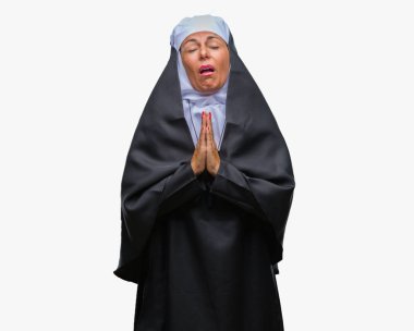 Orta yaş üst düzey Hıristiyan Katolik Rahibe kadın dilencilik ve umut ifade yüzünde çok duygusal ve endişe ile birlikte elleriyle dua izole arka plan yüzünden. Bağışlanmak. Din kavramı.