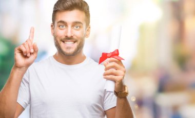 Yakışıklı delikanlı holding derecesi üzerinde arka plan ile bir fikir ya da gülen yüz, bir numara ile parmak işaret soru sürpriz izole