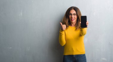 İşaret ve başparmak kadar mutlu yüz gülümseyen tarafı ile gösterilen orta yaş İspanyol kadın gösteren smarphone ekran