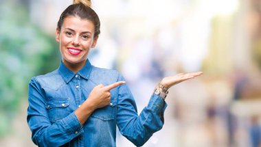 Genç güzel kadın üzerinden hayran ve el ile sunulması ve parmak ile işaret ederken kameraya gülümseyen izole arka plan.