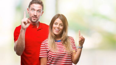 Başarılı fikirle parmağı yukarıyı izole arka plan üzerinde aşık genç bir çift. Çıktıktan ve mutlu. Bir numara.