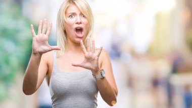 Şokta bağırarak genç güzel sarışın kadın izole arka plan korkuyor ve korku ifade dur hareketi el ile ile dehşete. Panik kavramı.