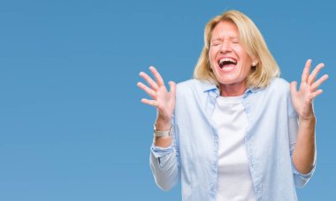 Orta yaş sarışın kadın izole arka plan çılgın ve kızgın bağırarak ve agresif ifade ve silah kaldırdı bağırıyor. Hayal kırıklığı kavramı.