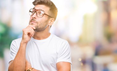 Çene düşünme hakkında soru, dalgın ifade üzerine el ile izole arka plan üzerinde gözlük takan yakışıklı delikanlı. Düşünceli yüzüyle gülümsüyor. Şüphe kavramı.