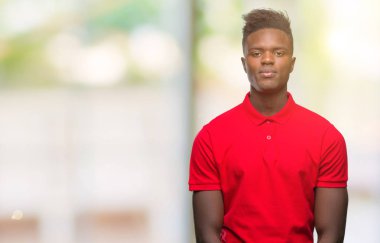 Afrikalı-Amerikalı genç yüzünde ciddi bir ifade ile izole arka plan üzerinde. Basit ve doğal kameraya bakıyor.