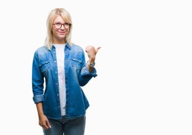 Seyir ve başparmak yanında yukarıyı mutlu yüz ile gülümseyen izole arka plan üzerinde gözlük takan genç güzel sarışın kadın.