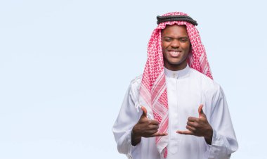 Geleneksel keffiyeh izole arka plan başarı işareti el ile pozitif jest yapıyor üzerinde giyen genç Arapça Afrika adam başparmak gülümseyen ve mutlu. Neşeli bir ifadeyle, kazanan jest kameraya bakıyor.