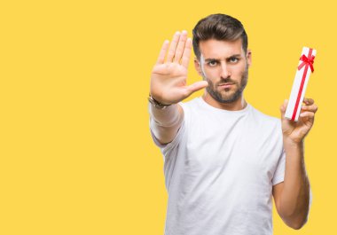 Sevgililer hediye izole arka plan üzerinde açık eliyle dur işareti ile ciddi ve kendine güvenen ifade, savunma jest yapıyor veren aşık genç yakışıklı adam