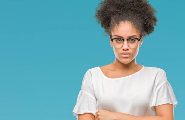 İzole arka plan şüpheci ve çapraz kolları olan yüzündeki gergin, onaylamayan ifade gözlüklü genç afro Amerikalı kadın. Negatif kişi.