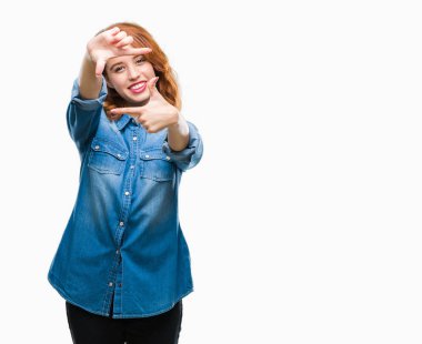 Genç güzel kadın elle yapma çerçeve ve parmakları ile mutlu yüz gülümseyen izole arka plan yüzünden. Yaratıcılık ve Fotoğrafçılık kavramı.