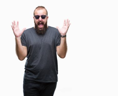Genç beyaz hipster adam kızgın ve silah ile başarı için deli izole arka plan kutluyor üzerinde güneş gözlüğü takıyor kaldırdı ve heyecanlı çığlık gözler kapalı. Kazanan kavramı
