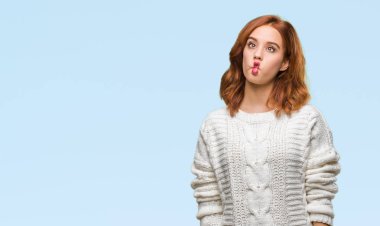 Genç güzel kadın izole arka plan giyen kış kazak yapımı balık yüzünden dudakları, çılgın ve komik bir jest ile karşı karşıya. Komik ifade.