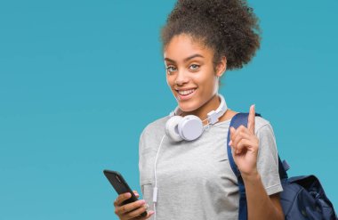 Tutan genç güzel afro Amerikan öğrenci kadın izole arka bir fikirle sürpriz üzerinde sırt çantası ya da gülen yüz, bir numara ile işaret parmağı soru