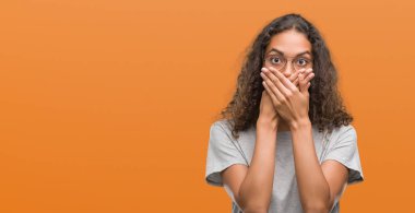 Hata için ellerle ağız kapsayan şok gözlüklü güzel genç İspanyol kadın. Gizli kavramı.