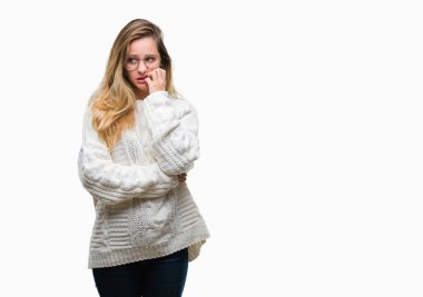 Kış kazak ve güneş gözlüğü stresli ve gergin elle çivi ısırma ağzına bakarak izole arka plan üzerinde giyen genç güzel sarışın kadın. Anksiyete sorunu.