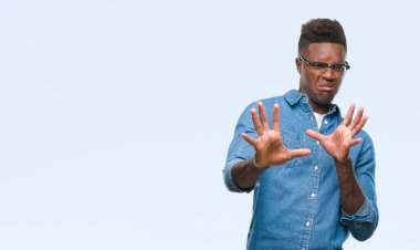 Şokta bağırarak genç Afro-Amerikan adam izole arka plan korkuyor ve korku ifade dur hareketi el ile ile çok korkmuş. Panik kavramı.