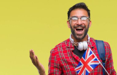 Yetişkin İspanyol öğrenci adam İngiltere pasaport holding büyük gülümseme ile çığlık zaferini kutluyor ve ellerini kaldırdı arka plan çok mutlu ve heyecanlı, kazanan ifade izole