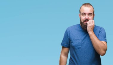 Genç beyaz hipster adam stresli ve gergin elle çivi ısırma ağzına bakarak izole arka plan üzerinde. Anksiyete sorunu.