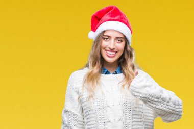 Hareketi el ile mutlu yaşasın yapıyor izole arka plan üzerinde Noel şapka giyen güzel genç sarışın kadın. Kameraya bakarak başarı gösteren ile ifade onaylama.