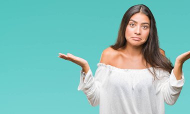 Genç güzel Arap kadın izole arka plan clueless ve şaşkın bir ifadeyle kollar ve eller kaldırdı. Şüphe kavramı.