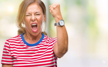 Orta yaş üst düzey İspanyol kadın izole arka plan öfkeli ve sinirli sinirli ve öfke ile bağırarak süre öfkeli yumruk yükselterek yüzünden. Öfke ve agresif kavramı.