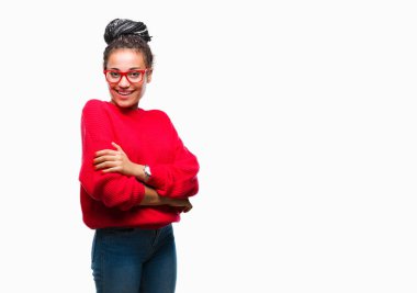 Genç örgülü saç Afro-Amerikan kız kameraya bakarak çapraz silah ile gülümseyen izole arka plan mutlu yüzüne kazak ve gözlük takıyor. Olumlu bir kişi.