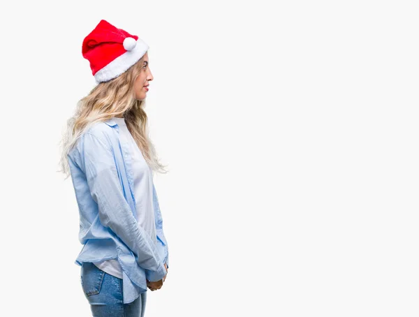 側を分離の背景に美しい若いブロンドの女性身に着けているクリスマスの帽子リラックス自信を持って笑顔で自然の顔を持つプロファイル ポーズ — ストック写真