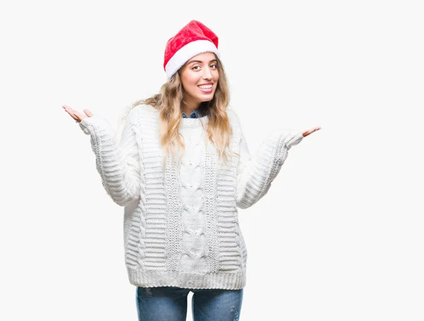 美丽的年轻的金发女子戴着圣诞节帽子在孤立的背景不清楚和混淆表达与胳膊和手提出 怀疑概念 — 图库照片
