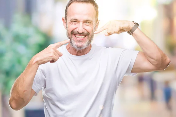 中年老人穿白色 T恤在孤立的背景微笑自信地显示和指着手指牙齿和嘴 健康理念 — 图库照片