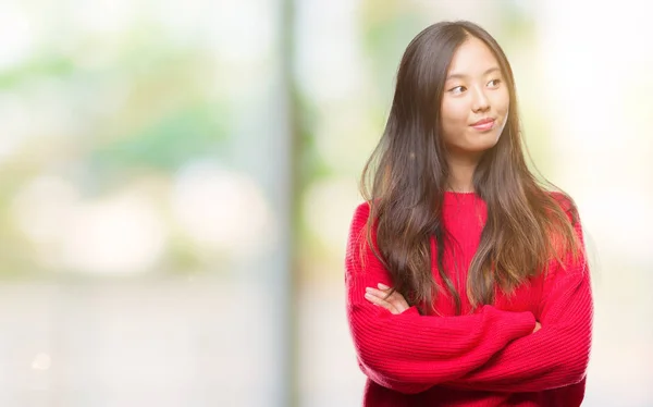 笑って見ている側と見つめて離れて思考孤立の背景の上冬のセーターを着た若いアジア女性 — ストック写真