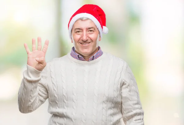 英俊的老人戴着圣诞节帽子在孤立的背景显示和指向与手指数字四同时微笑自信和快乐 — 图库照片