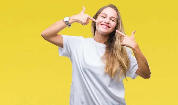 年轻美丽的金发女子穿着休闲白色 T恤在孤立的背景微笑自信显示和指着手指牙齿和嘴 健康理念 — 图库照片