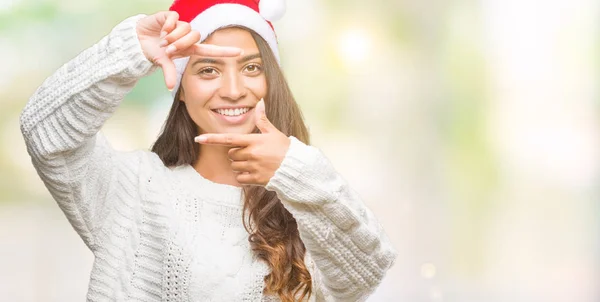 若いアラブの女性は 笑顔と幸せそうな顔で指手作りフレーム分離の背景にクリスマス帽子をかぶっています 創造性と写真のコンセプト — ストック写真