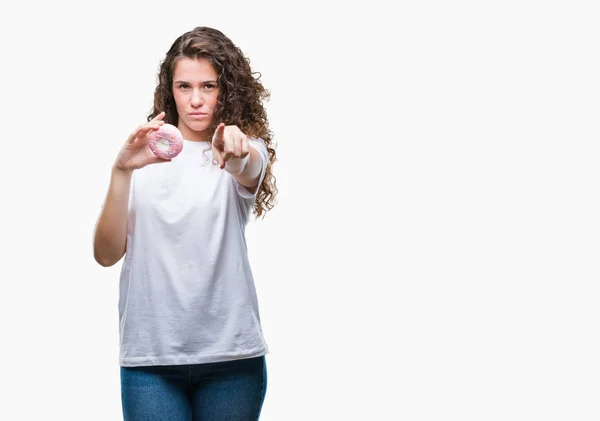 Joven Morena Comiendo Donut Sobre Fondo Aislado Señalando Con Dedo —  Fotos de Stock