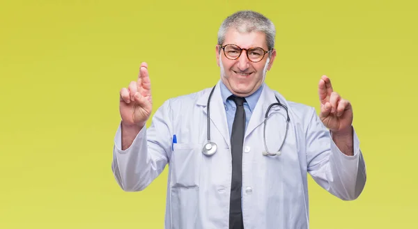 Bonito Médico Sênior Homem Sobre Fundo Isolado Sorrindo Cruzando Dedos — Fotografia de Stock