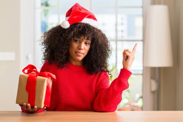 Africano Americano Mulher Segurando Presente Vestindo Natal Chapéu Vermelho Muito — Fotografia de Stock