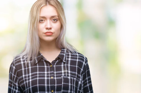 Young blonde woman over isolated background with serious expression on face. Simple and natural looking at the camera.