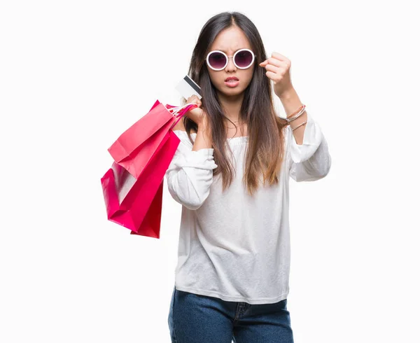 Young Asian Woman Holding Shopping Bags Sales Isolated Background Annoyed — Stock Photo, Image