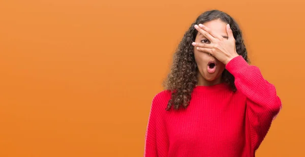 Jovem Hispânica Vestindo Camisola Vermelha Espreitando Choque Cobrindo Rosto Olhos — Fotografia de Stock