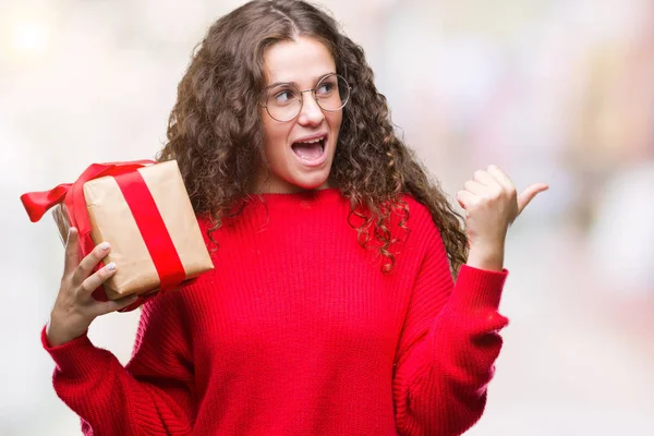 Joven Morena Sosteniendo Regalo Sobre Fondo Aislado Apuntando Mostrando Con — Foto de Stock