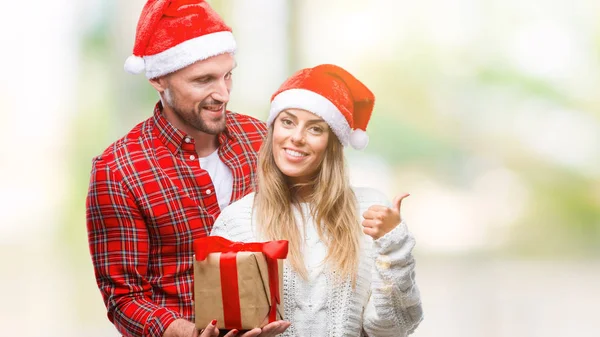 Joven Pareja Enamorada Vistiendo Sombrero Navidad Sosteniendo Presente Sobre Fondo — Foto de Stock